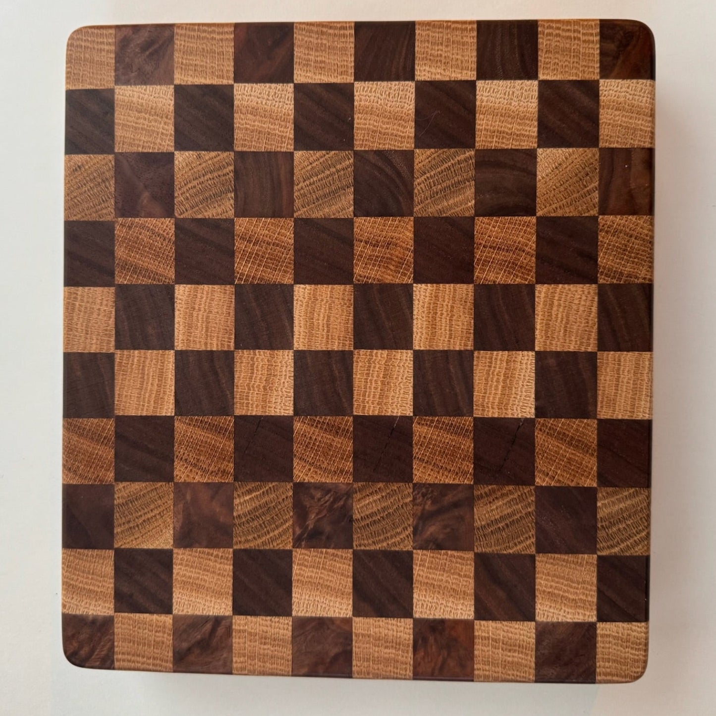 Wooden cutting board with a checkered pattern on a white background