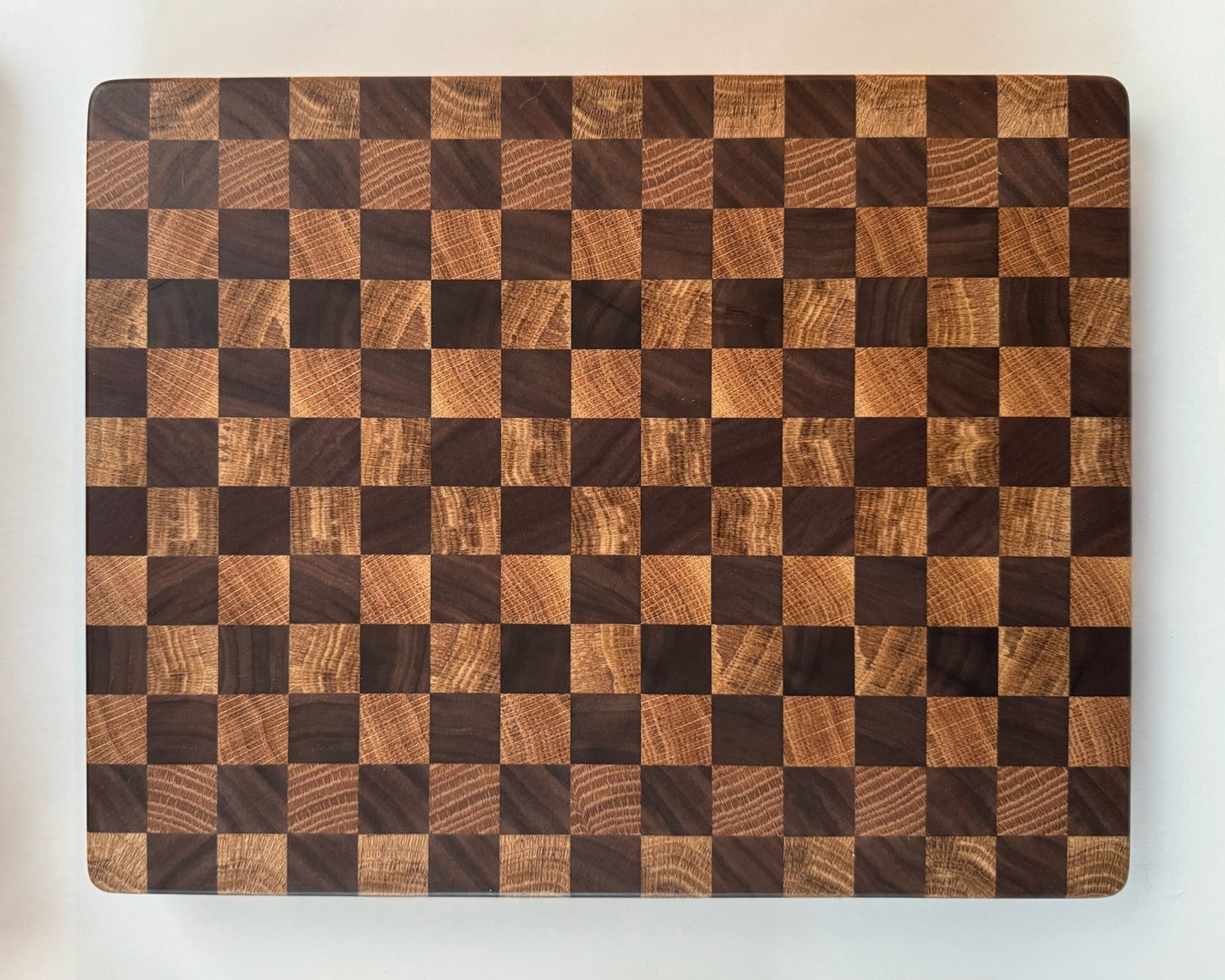 Wooden cutting board with checkered pattern on a white background