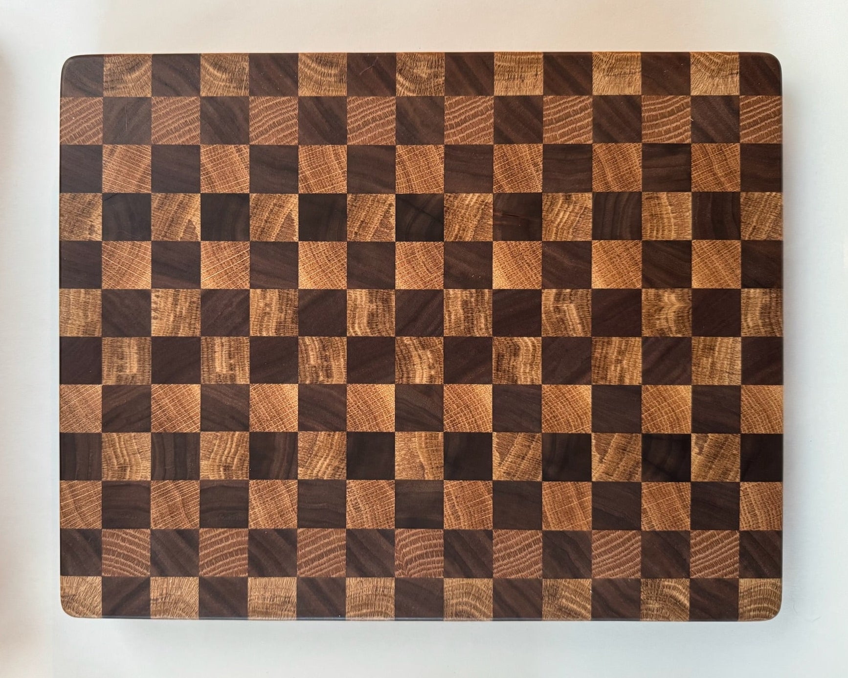 Wooden cutting board with checkered pattern on a white background